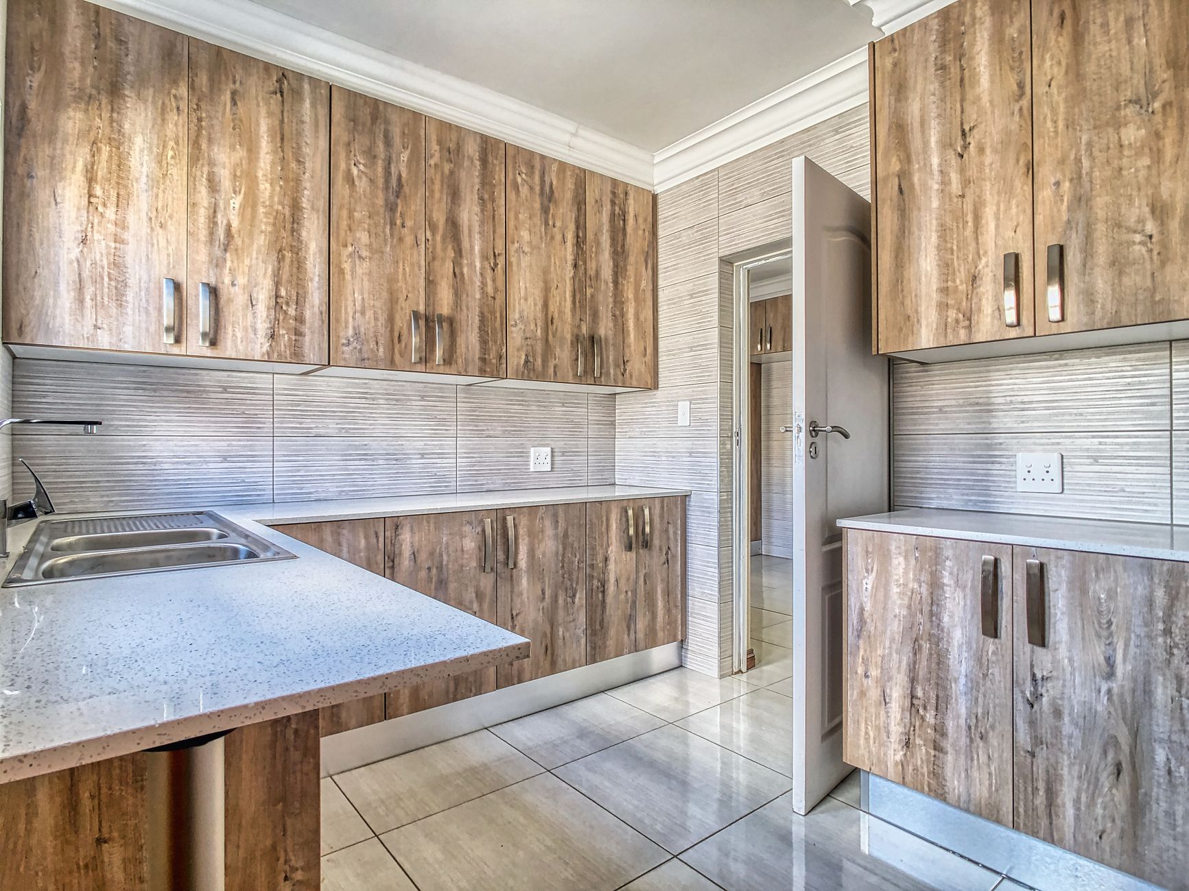 Bright kitchen interior featuring wood cabinets and quartz countertops with modern design in Temecula, CA