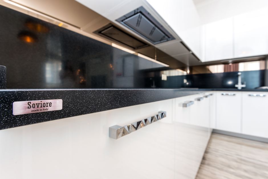 Modern kitchen with white cabinets and a light countertop.